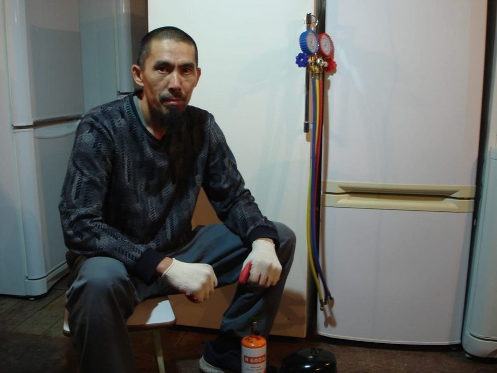 Мастер с манометрической станцией у холодильника, баллон хладагента R600a